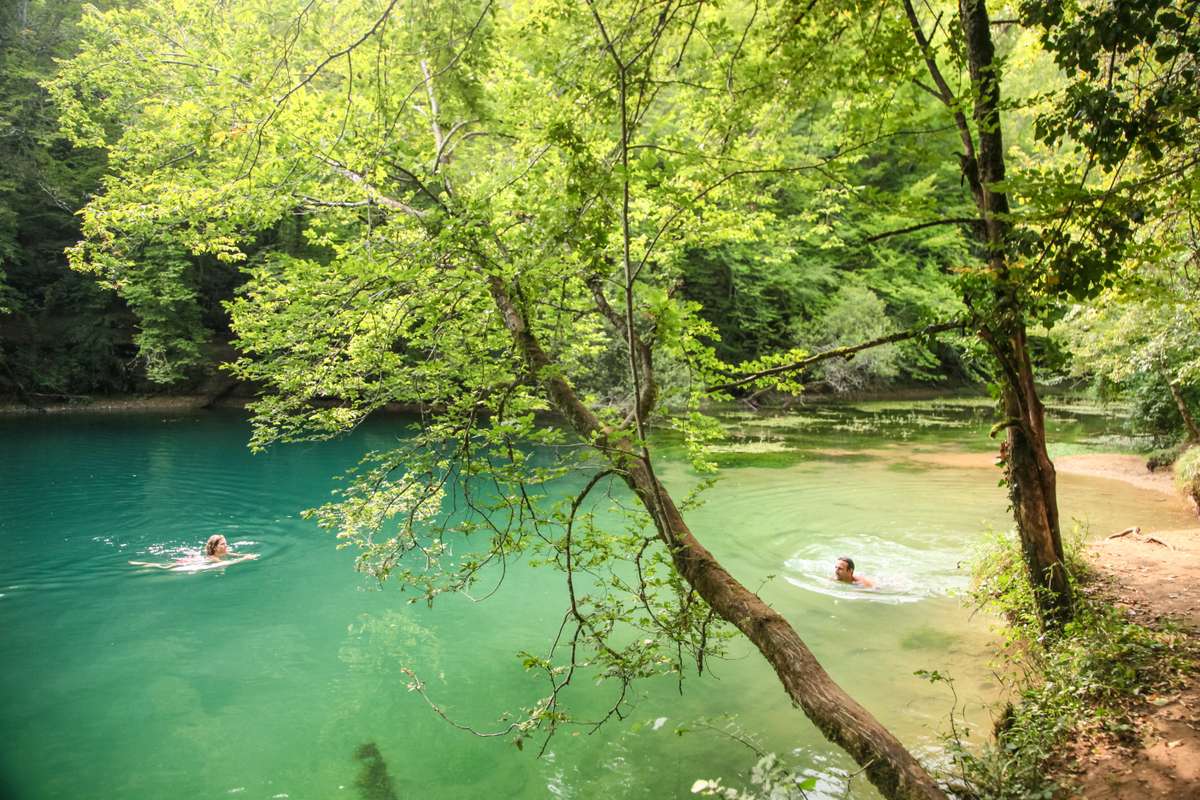Plage de rivière en Périgord Noir, eau émeraude entourée d’arbres